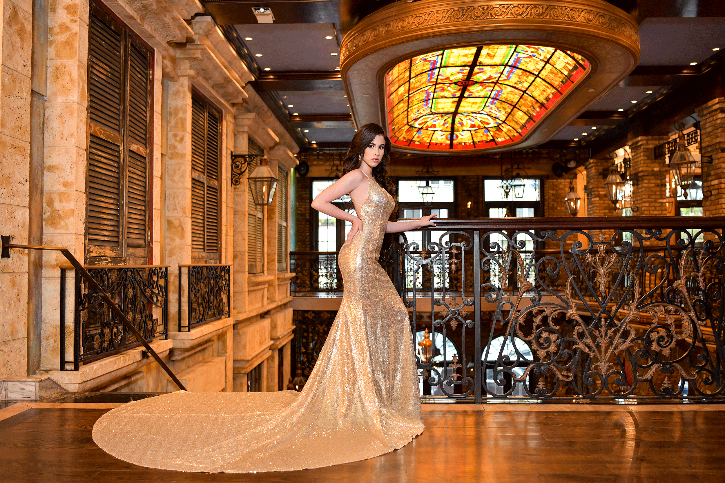 Quinceañera at the Cruz building in a gold dress Photo by Quinceanera Photo Studio.
